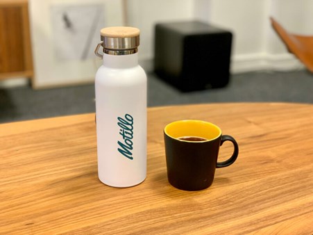 Vit flaska och svart kaffekopp